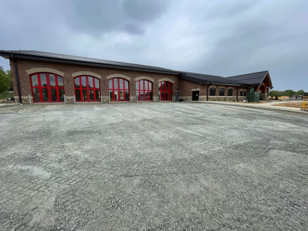 Brick building with large red doors and gravel lot