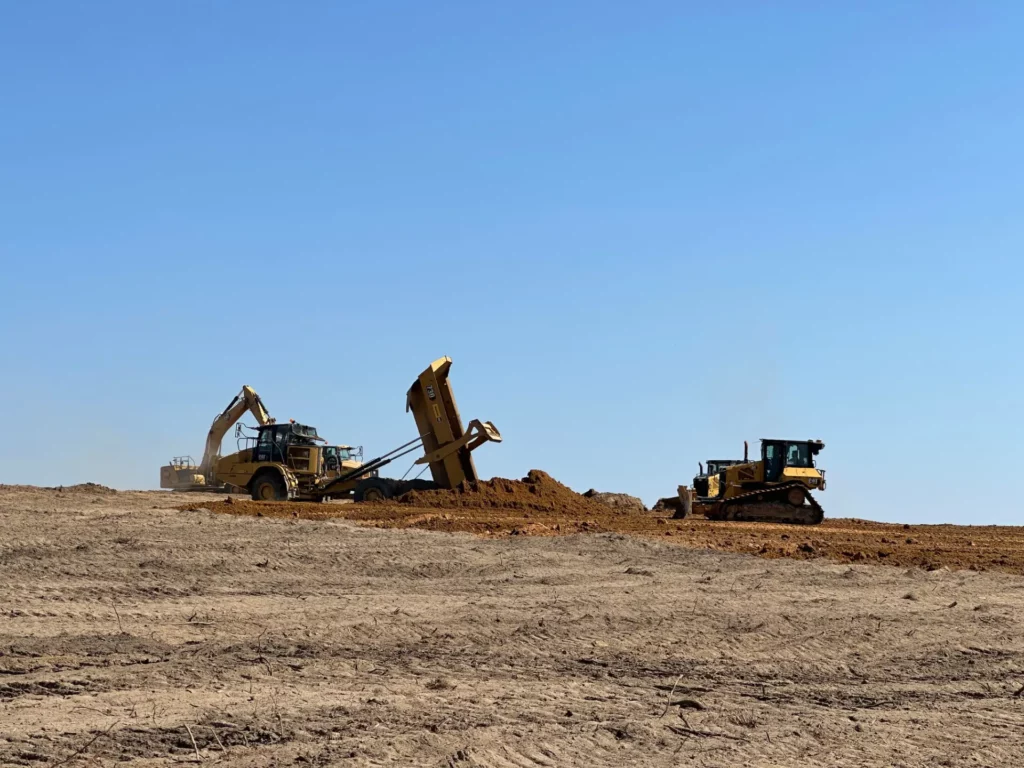Excavator loading dirt onto dump truck at construction site