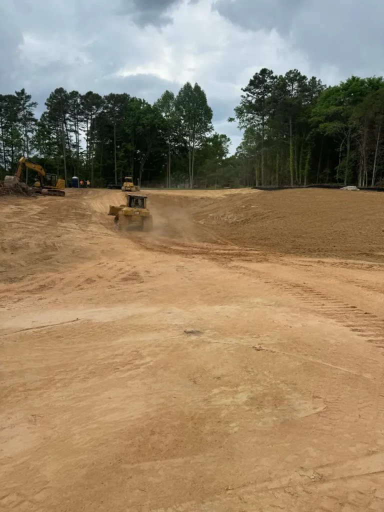 Construction site with bulldozer and excavator among trees